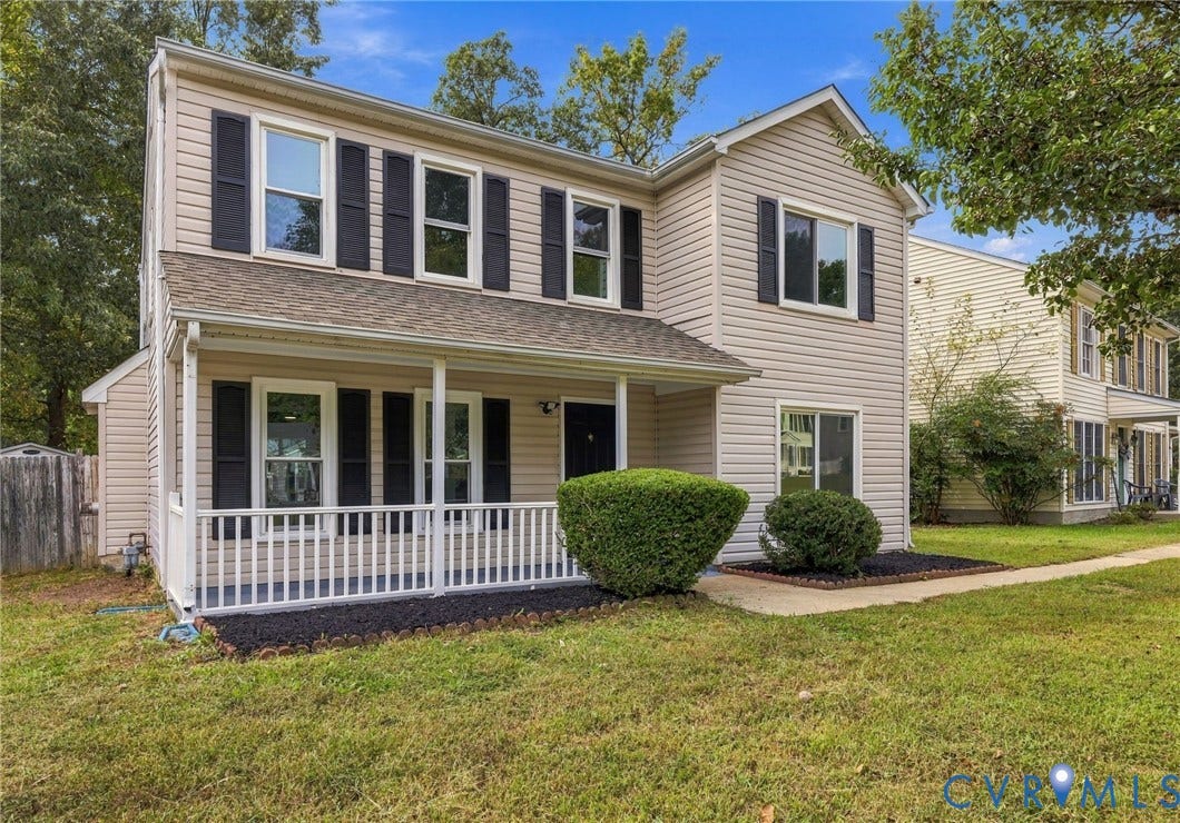 5831 Larrymore Road, Richmond, VA 23225 Two-story residence featuring light-toned vinyl siding, decorative window shutters, an expansive covered front porch with white railing, and a shingled roof