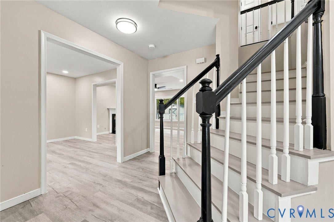 5831 Larrymore Road, Richmond, VA 23225 Entryway featuring wood-finish flooring, a staircase with contrasting black handrails and white balusters, and recessed ceiling lighting