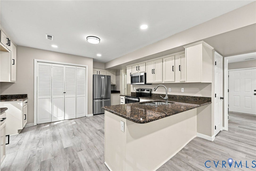 5831 Larrymore Road, Richmond, VA 23225 Kitchen featuring a stone-look countertop, stainless steel appliances, white cabinetry with matte black hardware, and wood-finish flooring