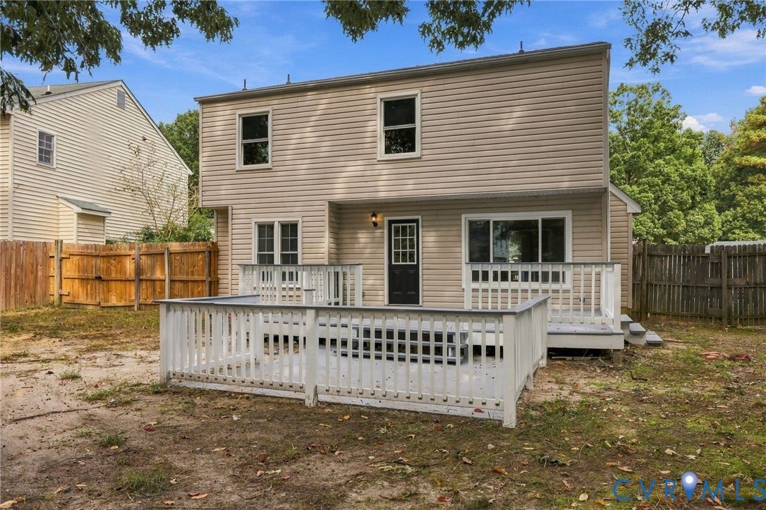 5831 Larrymore Road, Richmond, VA 23225 Rear exterior featuring a beige siding finish, multi-level painted wood deck with perimeter railing, and wood privacy fencing