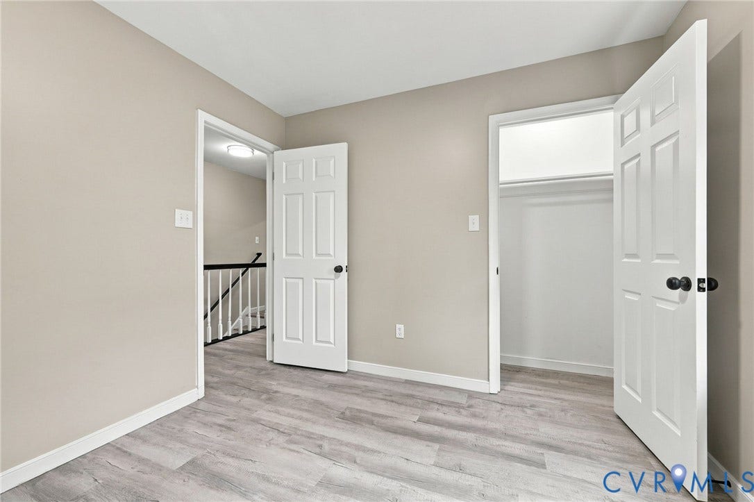 5831 Larrymore Road, Richmond, VA 23225 Neutral-toned room featuring wood-finish flooring, six-panel interior doors, and a built-in closet with an overhead light fixture