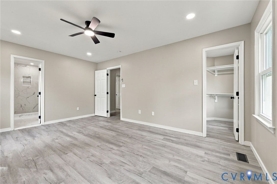 5831 Larrymore Road, Richmond, VA 23225 Neutral-toned interior featuring wood-finish flooring, a multi-blade ceiling fan with integrated lighting, recessed ceiling lights, and two doorways providing access to a walk-in closet and additional interior space