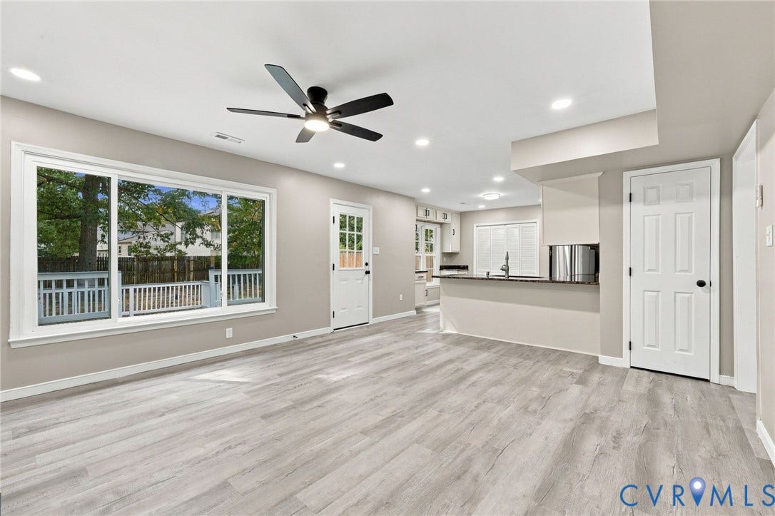 5831 Larrymore Road, Richmond, VA 23225 Open-concept interior featuring wood-finish flooring, a large picture window, a matte black ceiling fan with integrated lighting, recessed lighting, and a breakfast bar