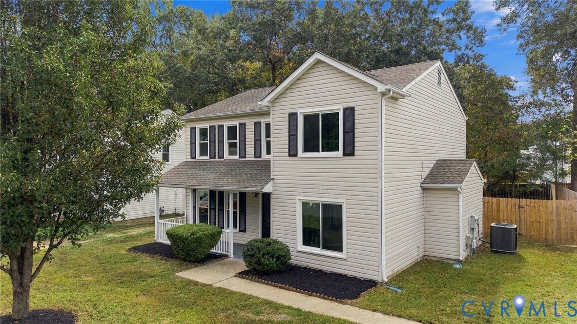 5831 Larrymore Road, Richmond, VA 23225 Two-story residence featuring light-colored horizontal siding, dark window shutters, a covered front porch with railings, and a wood privacy fence