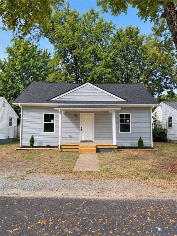 2727 Toledo Avenue, Richmond, VA 23234 Light gray siding exterior with a dark shingle roof, a covered front porch featuring a wood floor, and a white entry door