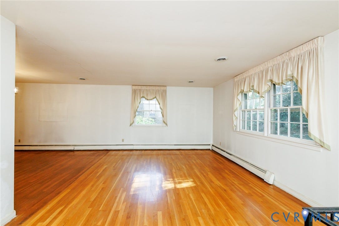 Spacious room featuring wood-finish flooring, multi-pane windows, and recessed lighting