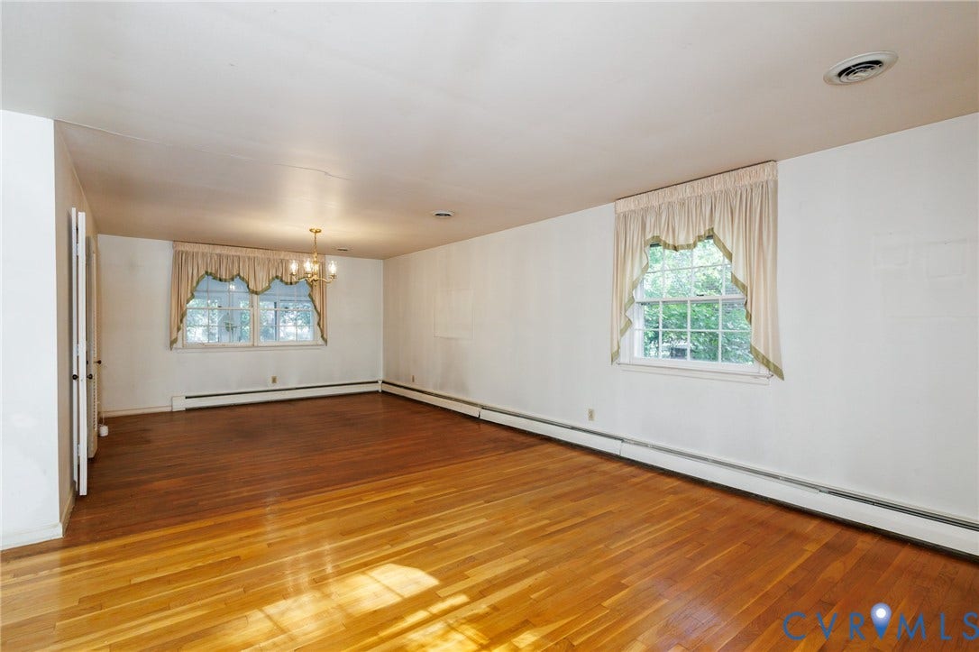Interior space featuring wood-finish flooring, multi-pane windows, and a multi-arm chandelier