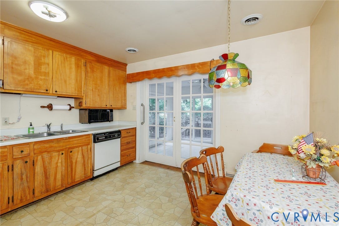 Kitchen featuring natural wood cabinetry, integrated stainless steel double-basin sink, built-in microwave, and multi-light French doors