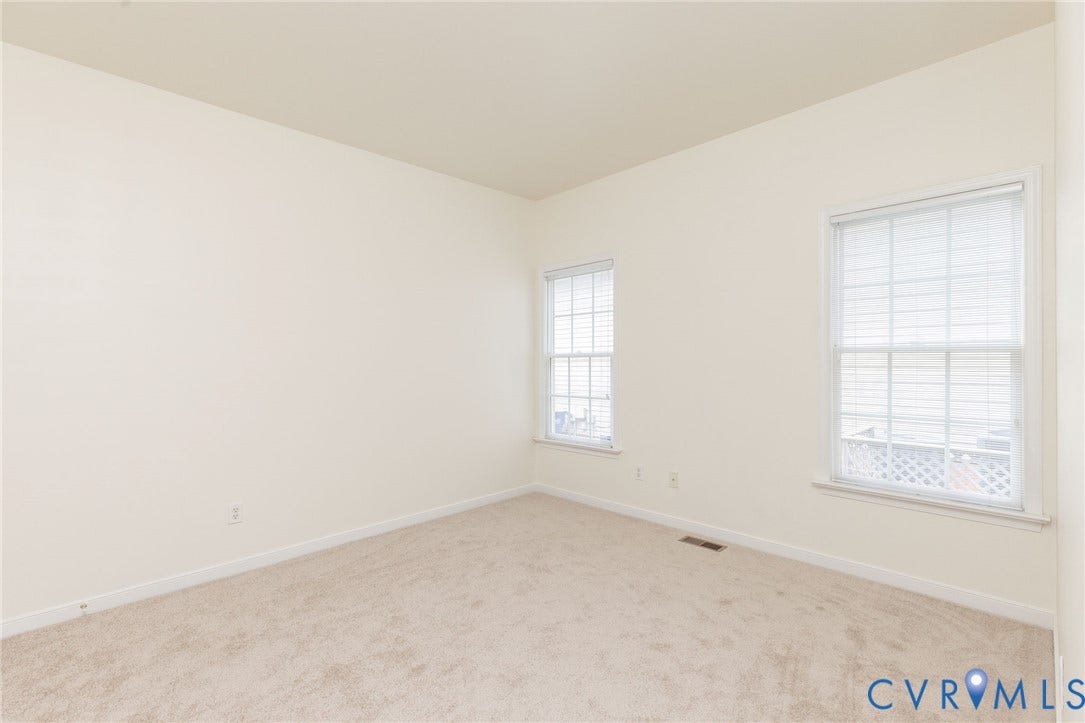 13742 Spyglass Hill Circle, Chesterfield, VA 23832 Neutral-toned interior space featuring light-colored wall-to-wall carpeting, high ceilings, and dual windows with white gridded panes