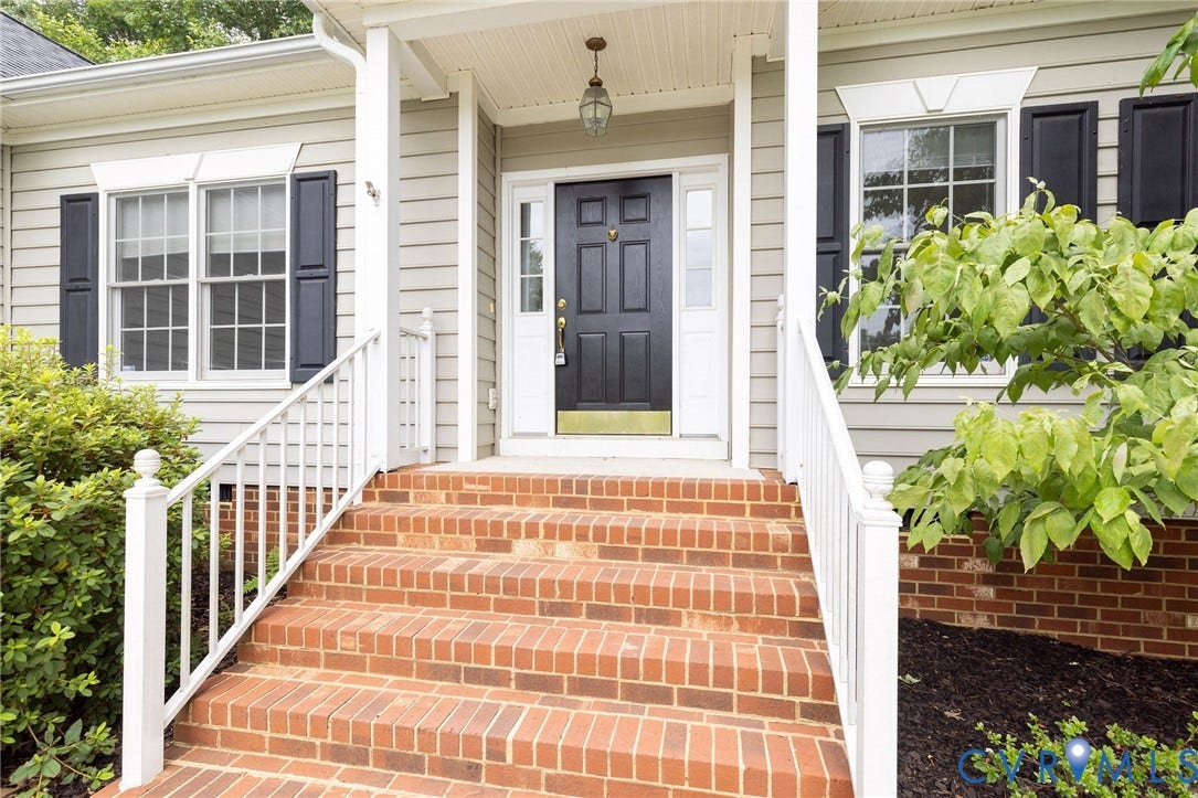 13742 Spyglass Hill Circle, Chesterfield, VA 23832 Exterior entry featuring a covered porch, brick steps with white railings, a multi-paneled door with sidelights, and black decorative shutters