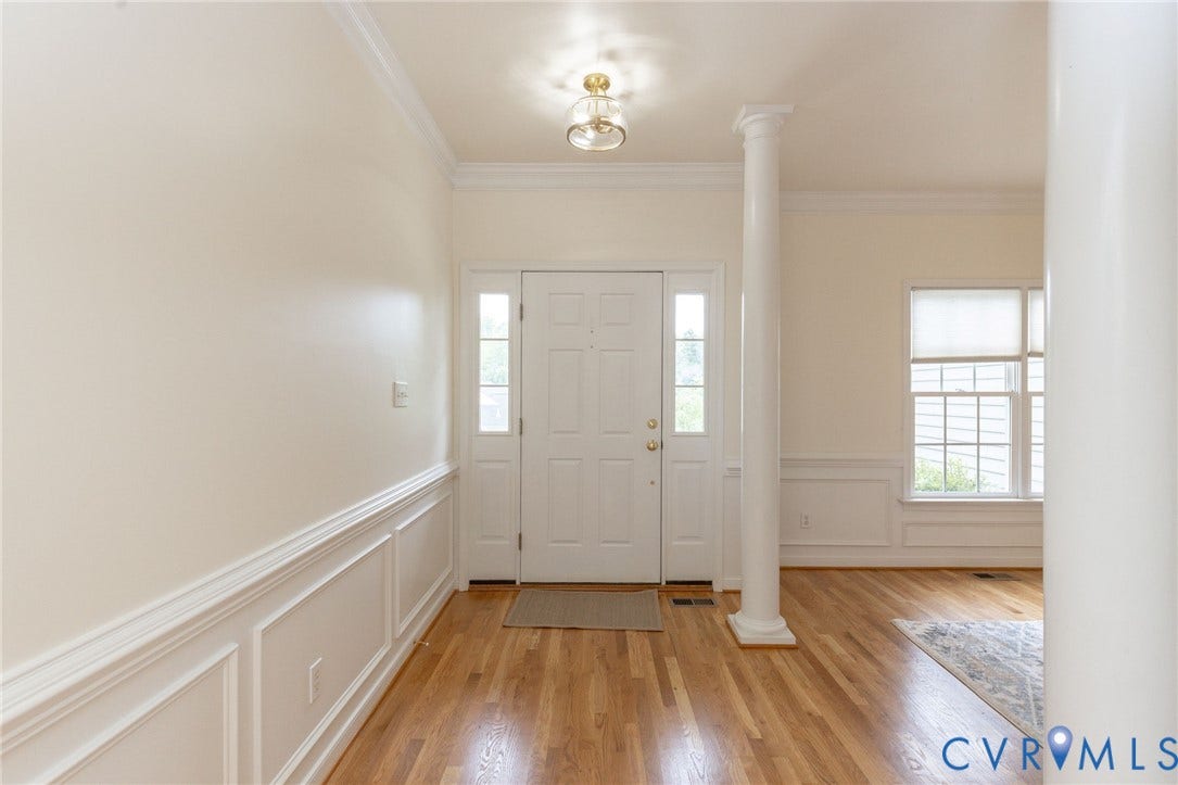 13742 Spyglass Hill Circle, Chesterfield, VA 23832 Entryway featuring wood-finish flooring, white panel wainscoting, a column, crown molding, and a multi-pane glass door with side lights
