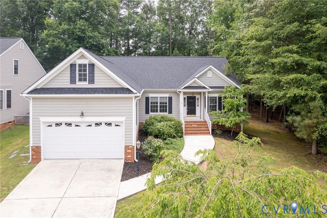 13742 Spyglass Hill Circle, Chesterfield, VA 23832 Gabled exterior featuring horizontal siding, brick foundation detailing, attached two-car garage, covered entryway with brick steps, and concrete driveway