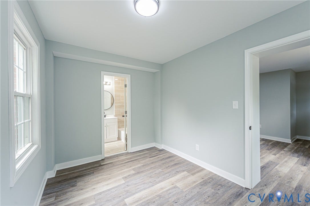 Light-colored walls, wood-finish flooring, white trim, and a ceiling-mounted light fixture
