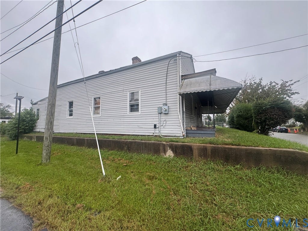 1400 N 29th Street, Richmond, VA 23223 Single-story exterior featuring horizontal siding, a covered side porch, and a concrete retaining wall