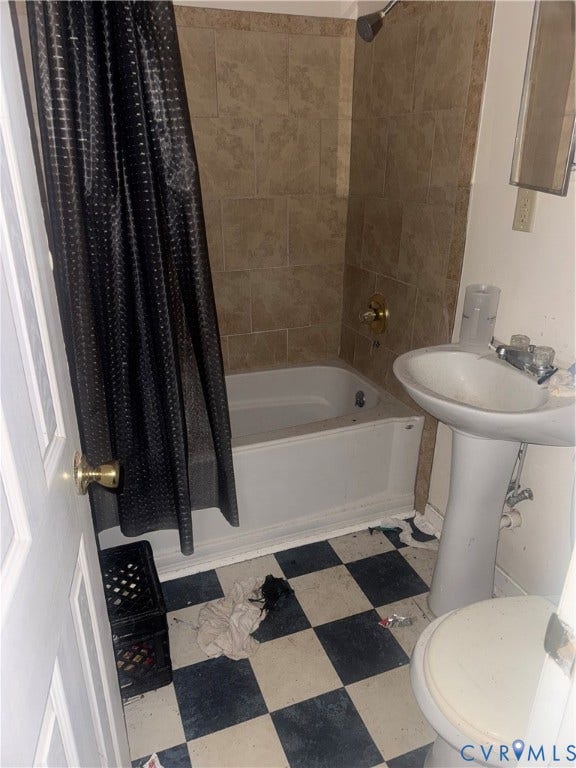 1400 N 29th Street, Richmond, VA 23223 Bathroom featuring a pedestal sink, a bathtub with a tiled surround, and checkered flooring