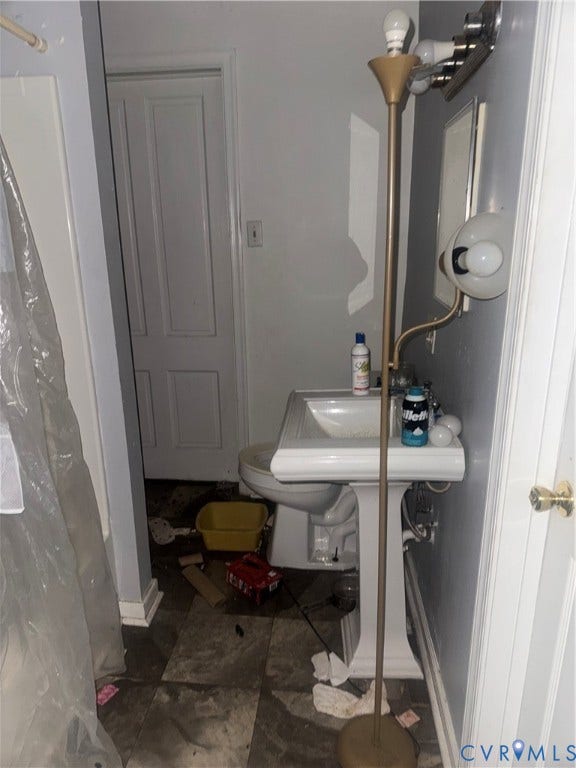 1400 N 29th Street, Richmond, VA 23223 Pedestal sink with integrated basin, wall-mounted multi-bulb lighting fixture, and tile flooring