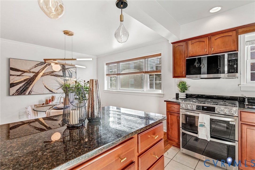 4520 Grove Avenue, #U5, Westhampton, Richmond, VA 23221 Kitchen featuring wood cabinetry, dark stone countertops, stainless steel appliances, and a kitchen island