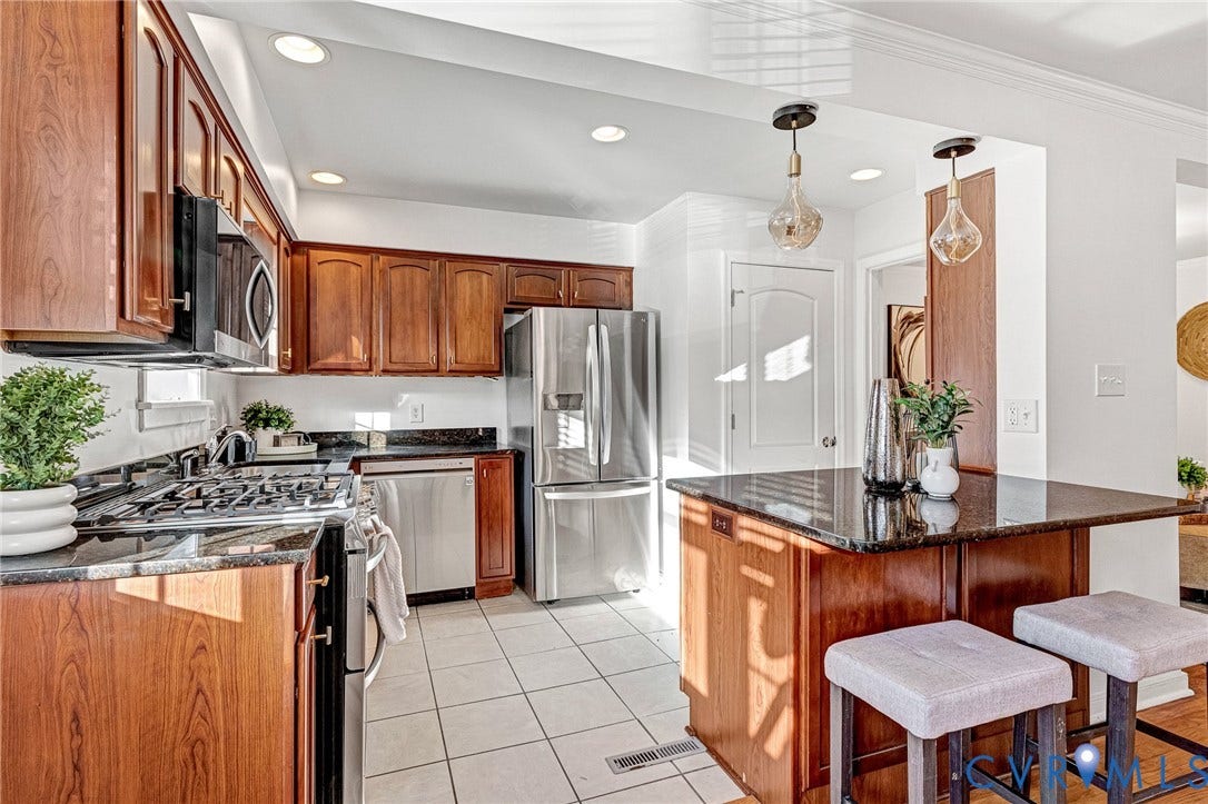 4520 Grove Avenue, #U5, Westhampton, Richmond, VA 23221 Wood-finish cabinetry complemented by black countertops, stainless steel appliances, and recessed lighting