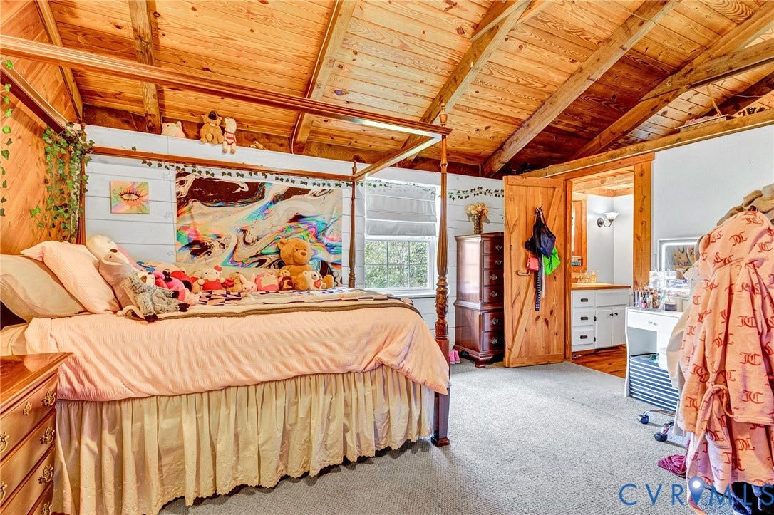 8328 Peaks Road, Hanover, VA 23069 Wood-plank ceiling with exposed beams, wood-plank accent wall, window with blinds, wood door, and carpeted flooring