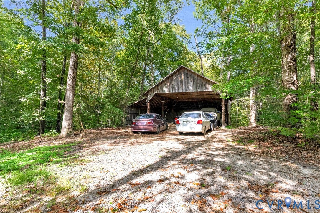 8328 Peaks Road, Hanover, VA 23069 Wood-sided barn structure with a covered parking area, set on a gravel surface
