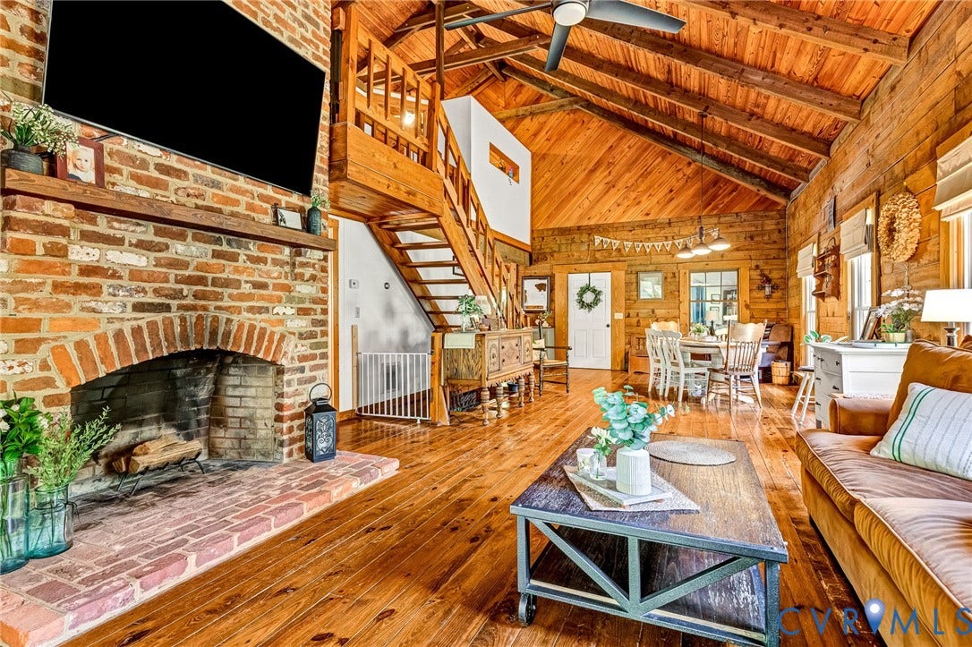 8328 Peaks Road, Hanover, VA 23069 Exposed brick fireplace with a wood mantle, wood-finish flooring, wood-paneled vaulted ceilings, and an open loft with wood railing