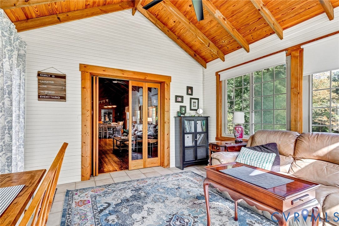 8328 Peaks Road, Hanover, VA 23069 Vaulted wood-finish ceiling with exposed beams, white shiplap walls, tiled flooring, wood-framed sliding glass doors, and multiple pane windows
