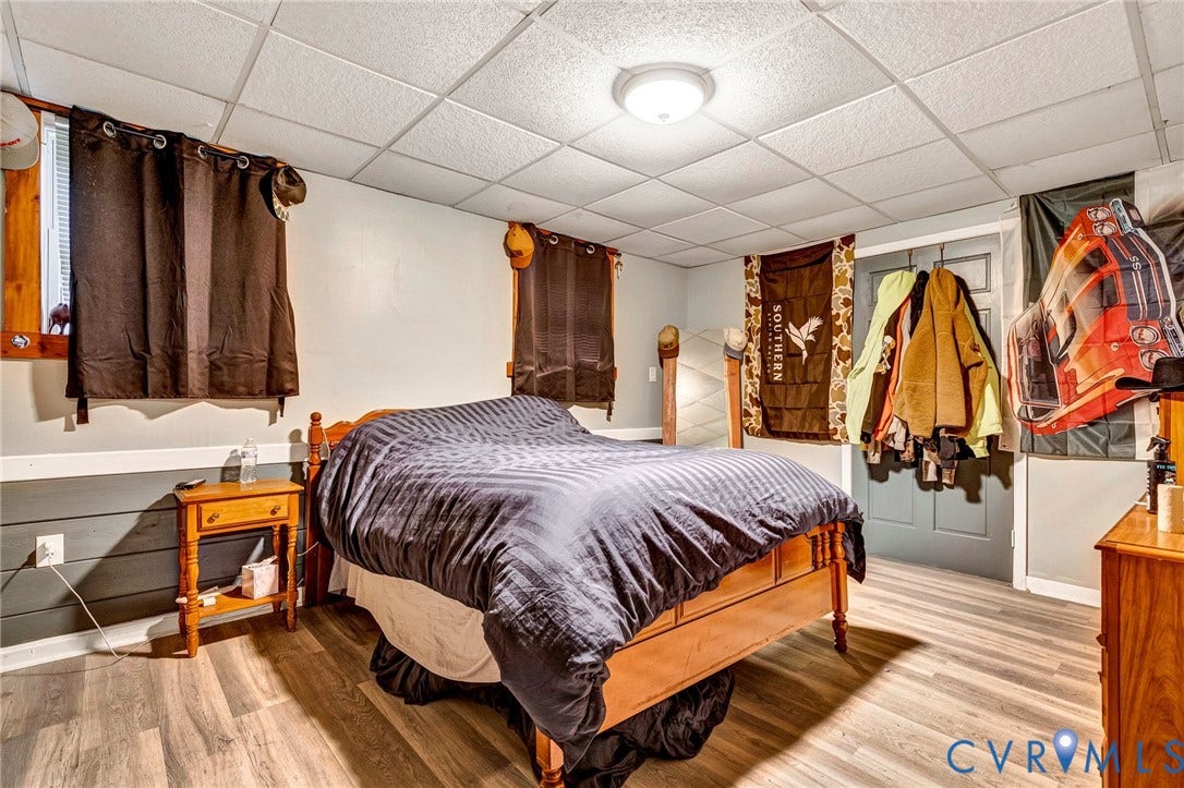 8328 Peaks Road, Hanover, VA 23069 Room featuring wood-finish flooring, drop ceiling with flush-mount lighting, and a painted paneled door