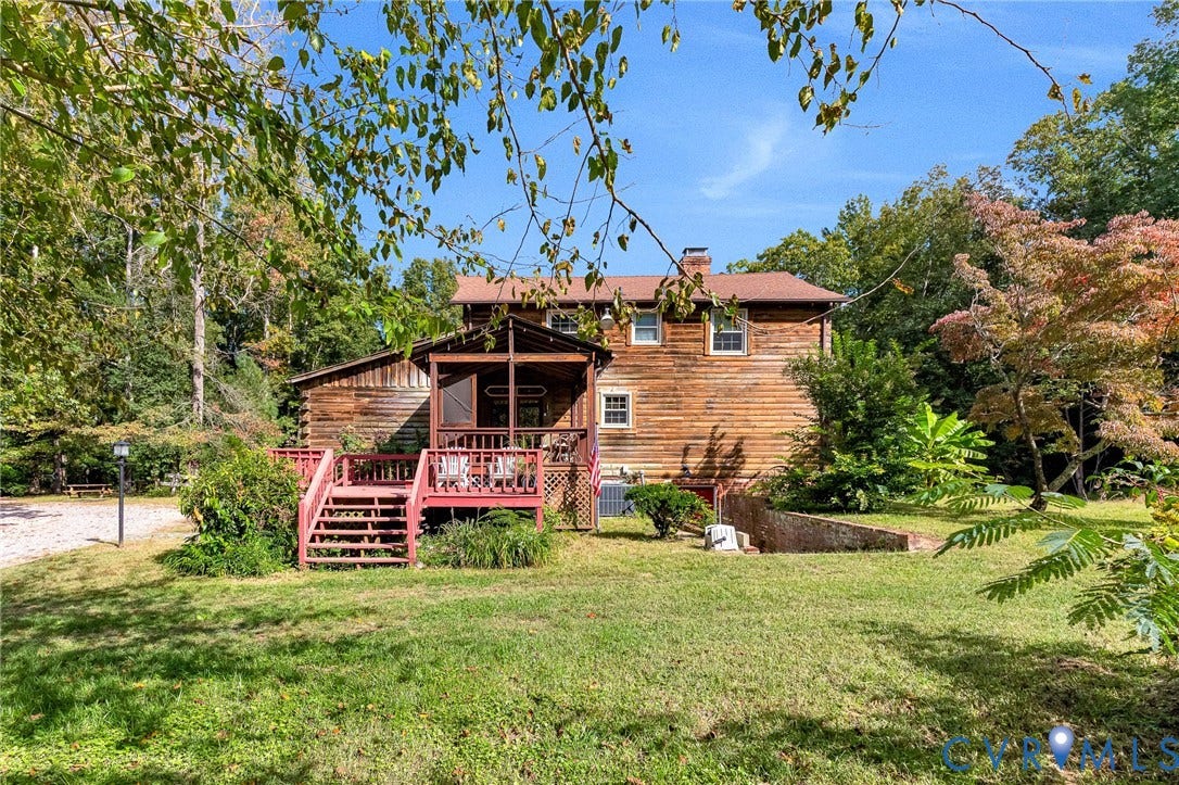 8328 Peaks Road, Hanover, VA 23069 Charming log-style residence featuring a wraparound front porch with wooden railings and entry stairs, cedar siding exterior, and a pitched roof with dormers