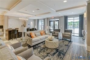 Expansive common area featuring wood-finish flooring, recessed lighting, double glass doors, and a decorative coffered ceiling