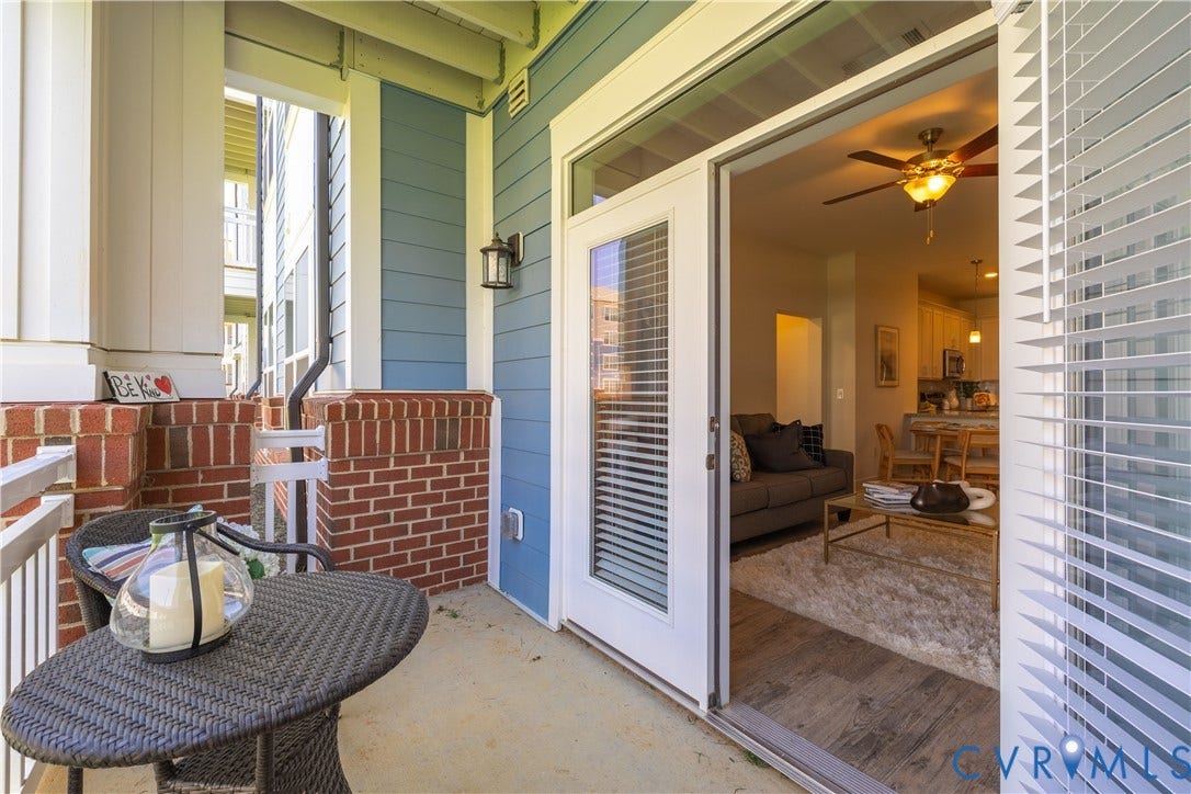 Outdoor patio with brick half-walls, white railings, and a blue siding exterior