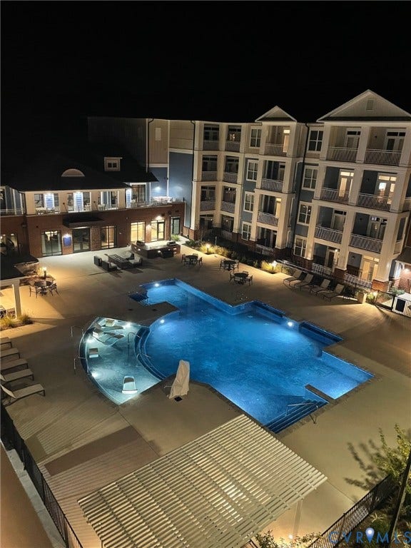 Resort-style pool with integrated spa, expansive paver decking, and multiple seating areas