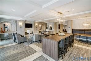 Spacious common area featuring wood-look flooring, decorative wall paneling, built-in shelving, and recessed lighting