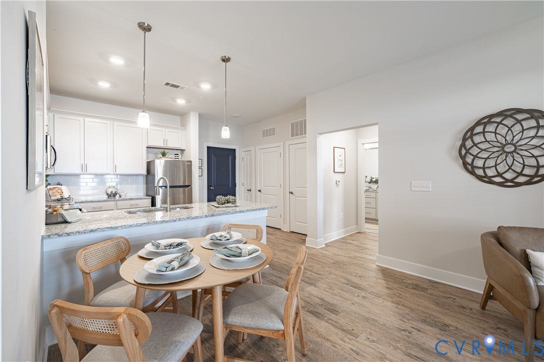 Kitchen island with a light-toned countertop, white cabinetry, and stainless steel appliances