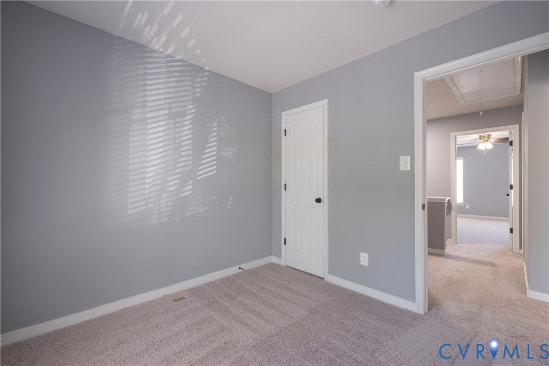 Bedroom #2 Neutral wall color, carpet flooring, interior door with black hardware, and an open doorway