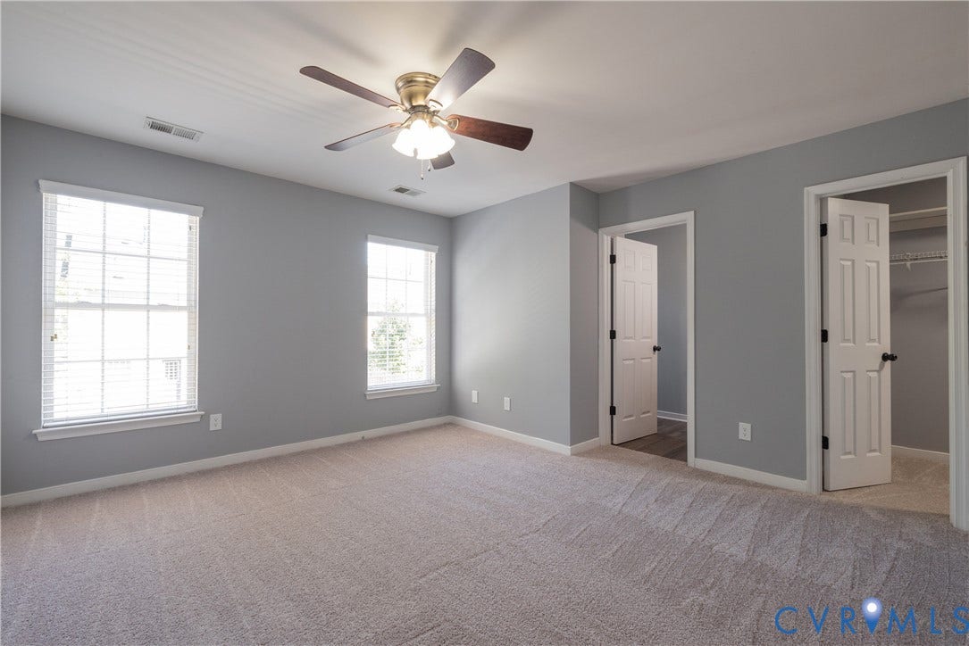 Recessed lighting, ceiling fan with integrated light, two paneled doors, and carpet flooring