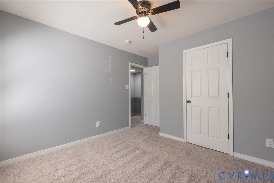Bedroom #3 Neutral gray walls, light-toned carpet flooring, white paneled doors, and a ceiling fan with integrated lighting