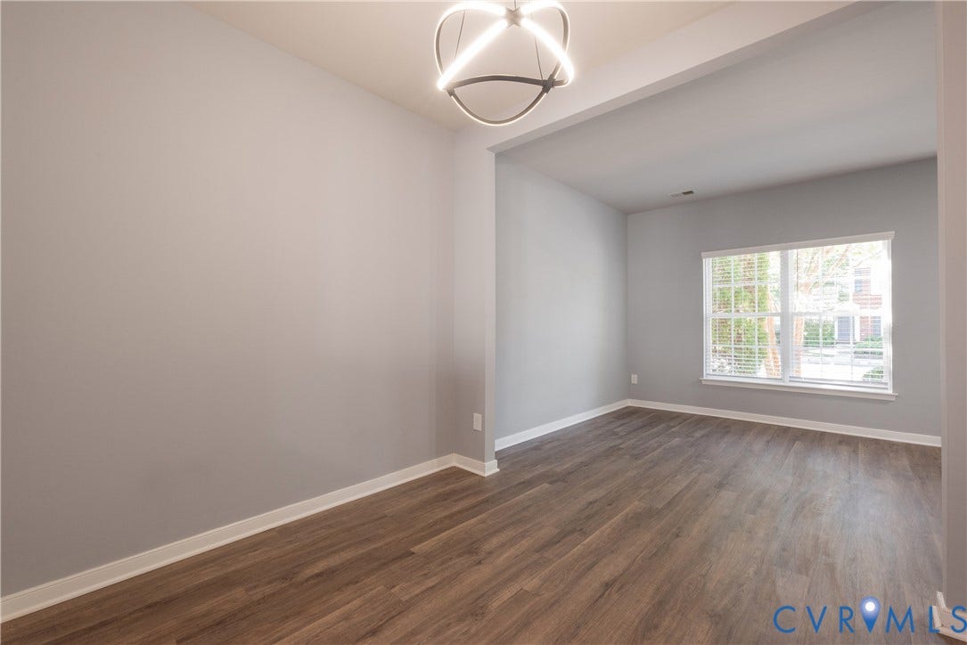 Wood-finish flooring, contemporary ceiling light fixture, neutral wall palette, and window with blinds
