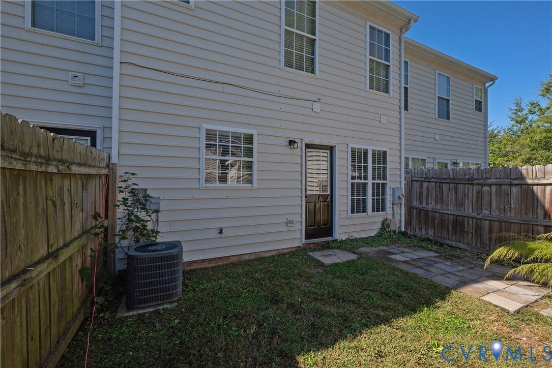 Private fenced yard featuring a concrete patio and a rear entry door