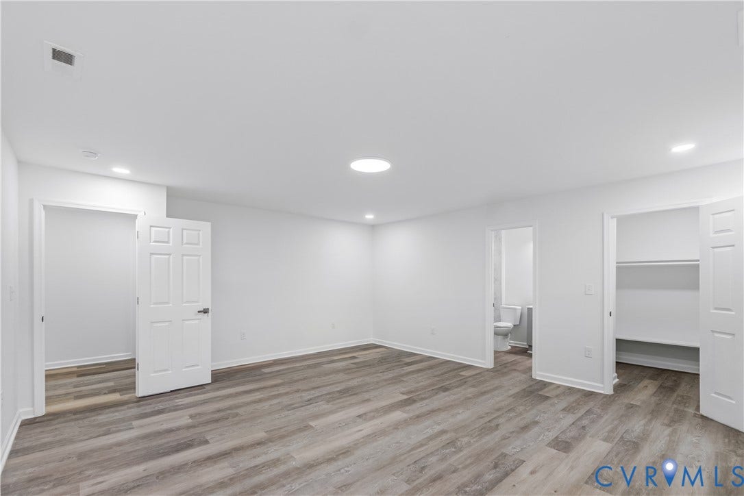 Spacious interior featuring wood-finish flooring, recessed lighting, and a skylight