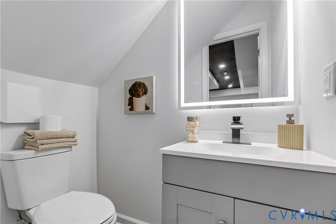 Modern vanity with a white countertop and dark-finish faucet