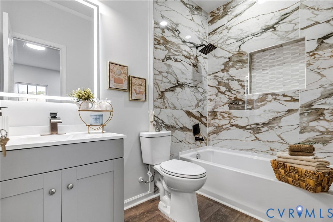 Bathroom featuring wood-finish flooring and a built-in tub