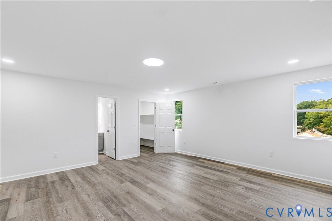 Recessed lighting, wood-finish flooring, multiple windows, built-in shelving, and a circular skylight
