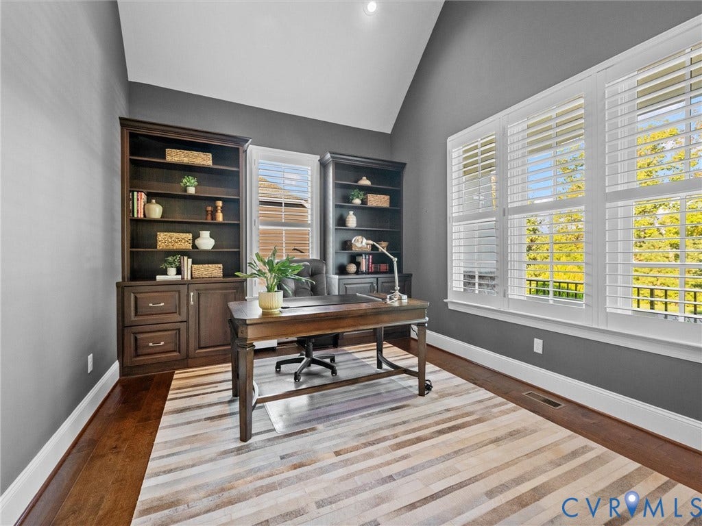 7750 Rock Cress Place, Chesterfield, VA 23120 Vaulted ceiling, built-in dark wood cabinetry with integrated shelving, dark wood-finish flooring, and large windows fitted with white plantation shutters