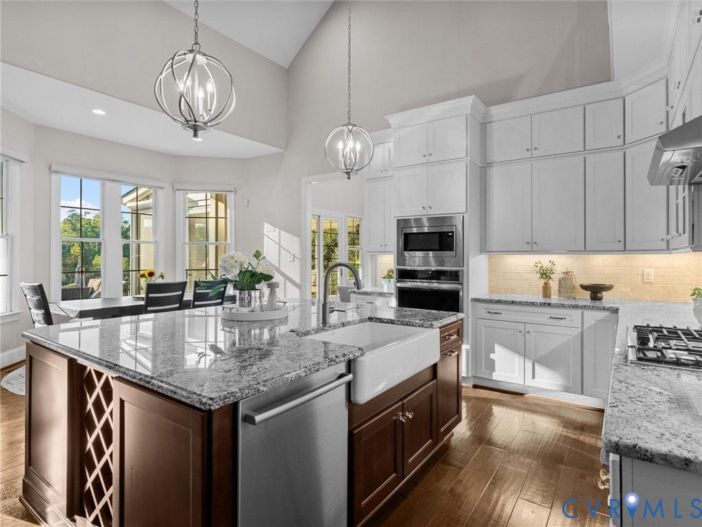 7750 Rock Cress Place, Chesterfield, VA 23120 Kitchen featuring vaulted ceilings, a central island with a farmhouse-style sink, built-in stainless steel double ovens, wood-finish flooring, and recessed globe-style pendant lighting