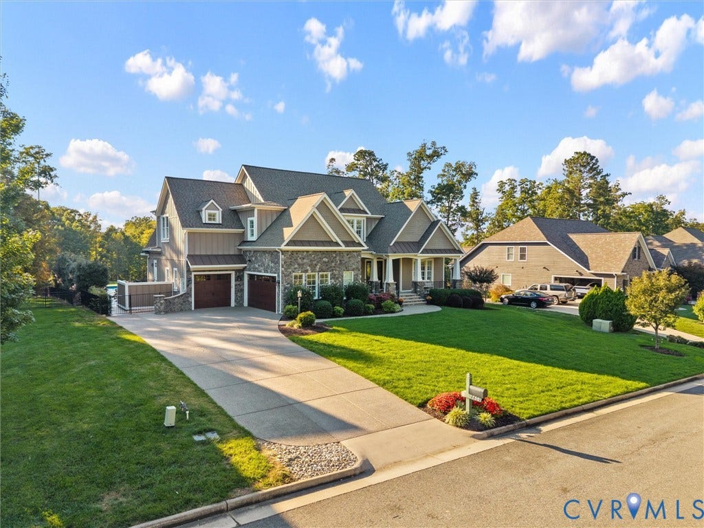 7750 Rock Cress Place, Chesterfield, VA 23120 Multi-gabled exterior featuring stone veneer, vertical siding, a concrete driveway, multi-car garage, and manicured landscaping