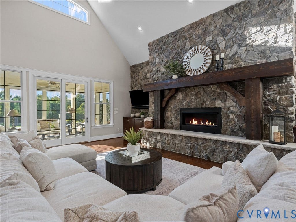 7750 Rock Cress Place, Chesterfield, VA 23120 Vaulted ceilings, full-height natural stone fireplace, heavy timber mantel, built-in hearth, and expansive grid-pane windows