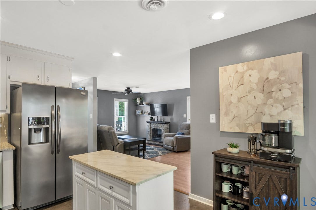 2724 Glen Point Circle, Henrico, VA 23233 Stainless steel side-by-side refrigerator, white upper cabinetry, kitchen island with light-toned countertop, recessed ceiling lighting, wood-finish flooring