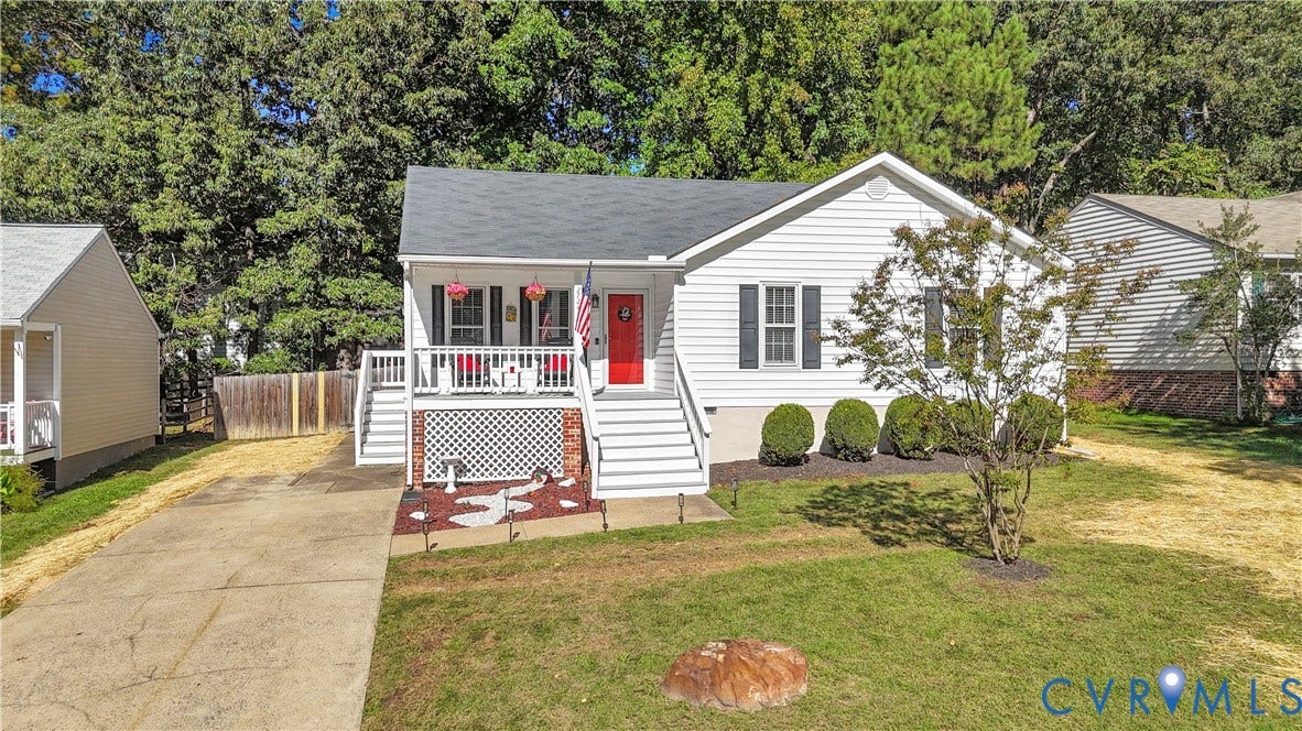 2724 Glen Point Circle, Henrico, VA 23233 White siding exterior with a dark shingle roof, featuring a covered front porch with white railings, a red front door, and mature landscaping