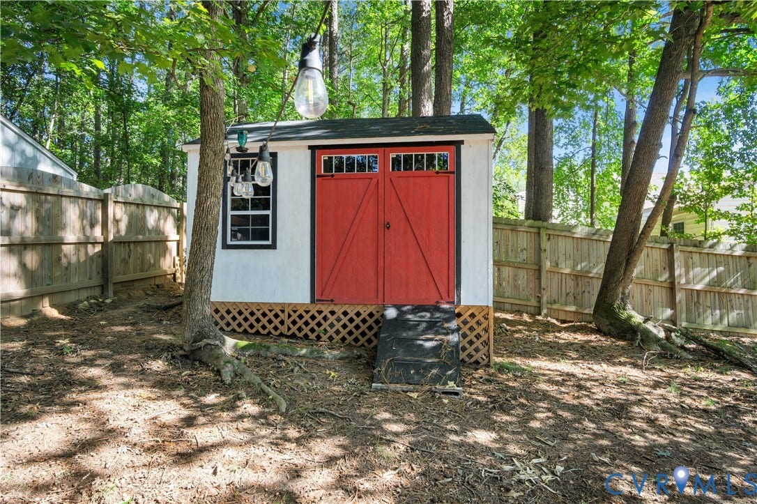 2724 Glen Point Circle, Henrico, VA 23233 Outbuilding featuring red barn doors, window, lattice skirting, and a dark roof
