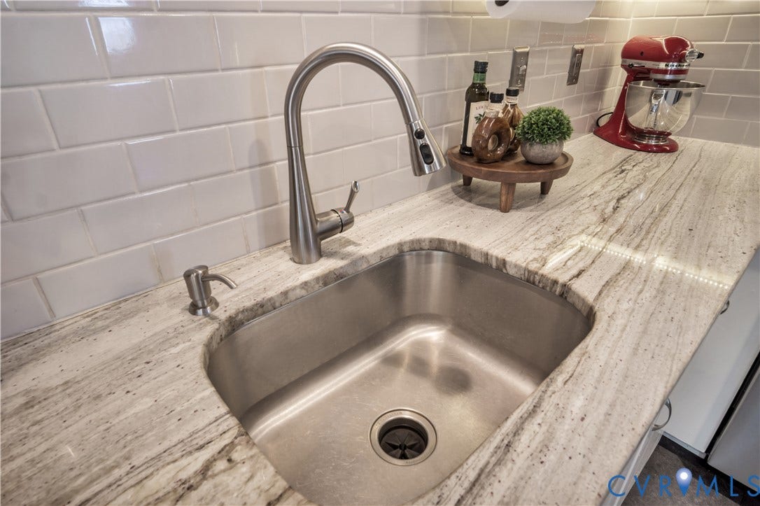 2724 Glen Point Circle, Henrico, VA 23233 Stainless steel undermount sink with a gooseneck faucet, set into a stone countertop, complemented by a white subway tile backsplash